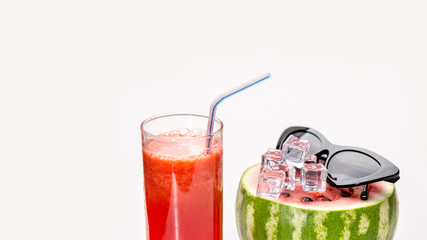 Fashion food concept. Watermelon juice smoothie sunglasses and pieces of ice over white background