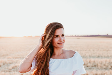 portrait of young beautiful woman on countryside at sunset