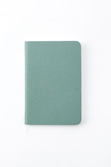 Top view of closed stitch blank recycled paper cover notebook on white background.