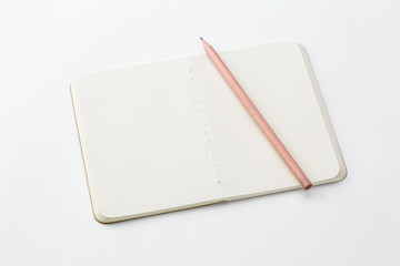 Top view of closed stitch blank recycled paper cover notebook with pencil on white background.