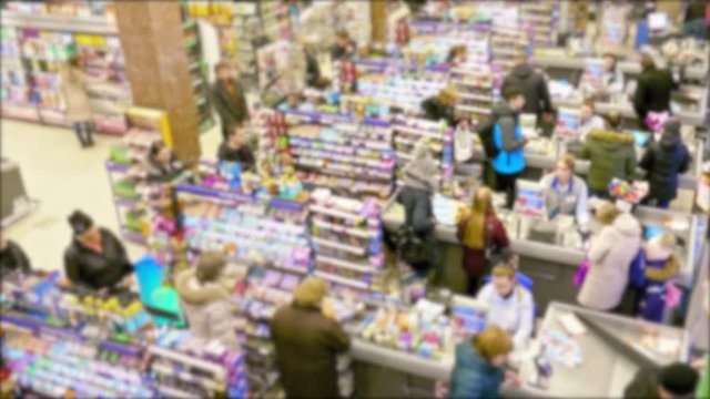 Cashier at supermarket / Retail checkout / Paying groceries. Unrecognizable buyers with carts move in queues to pay for purchases at the supermarket cashier. Fast motion.