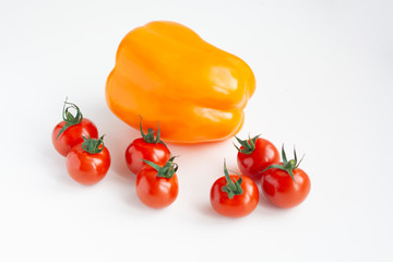 Yellow bell pepper and cherry tomatoes on a white background