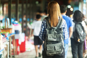 women backpack tourists travel in the market with a lot of people , tourism concep