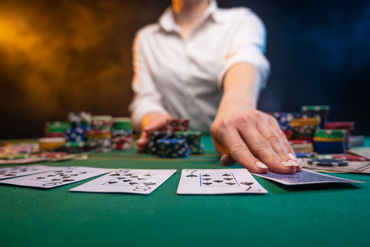 Playing poker in a casino, big bets, a lot of money. Cards, chips. A player plays poker, night club or game club.