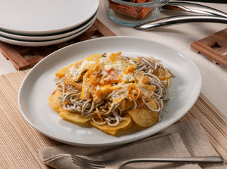 huevos rotos con gulas y patatas. broken eggs with eels and potatoes.