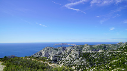 Fototapeta premium Blue sea and mountains nearby on a sunny day; beautiful coast under the blue sky