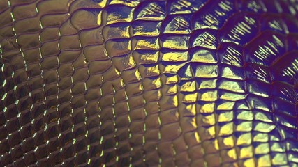 Synthetic Snakeskin Iridescent Texture close up. Glittery purple and gold background