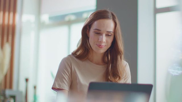 Businesswoman working on laptop at remote workplace. Woman using laptop at home