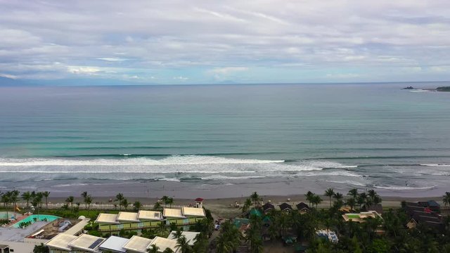 The city of Baler in the Philippines, known as the capital of surfing. Wide beach with big waves and surfers. Sabang Beach, Baler, Aurora, Philippines. Summer and travel vacation concept.