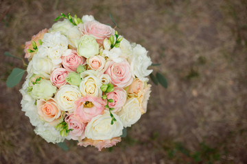 Top view of a beautiful delicate wedding bouquet of cream roses and eustoma.