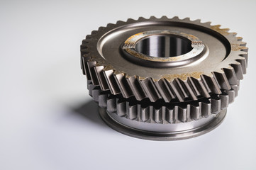 New parts on a gray background. Gears of gear shifting torque transmission. Conceptually mechanical...