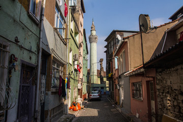 Fototapeta na wymiar Narrow street in Istanbul's historic district. View of the minaret of the ancient Akbiyik Mosque . Turkey