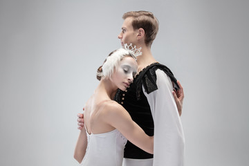 Hug. Graceful classic ballet dancers dancing isolated on white studio background. Couple in tender white clothes like a white swan characters. The grace, artist, movement, action and motion concept.