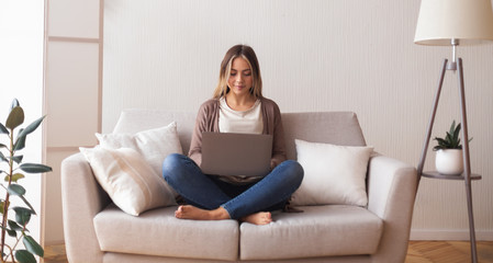 Obraz premium Young woman chatting with friend on laptop at home