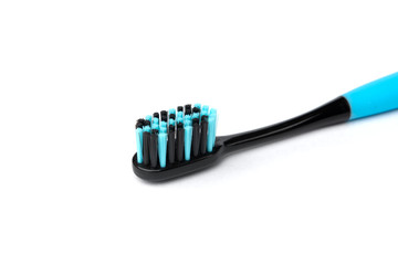 Blue toothbrush with black bristles isolated on white background.