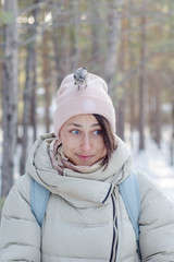 Russian girl in winter in a city park feeds hungry birds