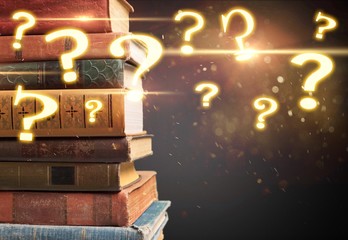 Collection of old books on dark background with question marks