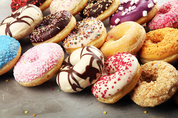 assorted donuts with chocolate frosted, pink glazed and sprinkles donuts