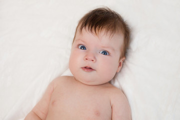 Newborn child relaxing in bed.