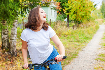 Young woman riding bicycle in summer city park outdoors. Active people. Hipster girl relax and...