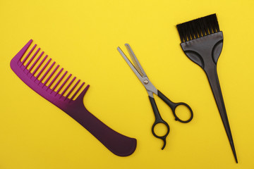 thinning scissors, comb and hair brush on a yellow background, space for text. Barber Tools. flat...