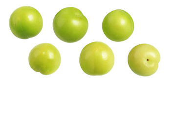 Green plums isolated on white background. Place for text. Close-up. Top view.