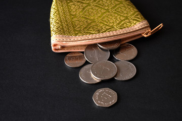 arab coins fall out of a canvas bag on black background