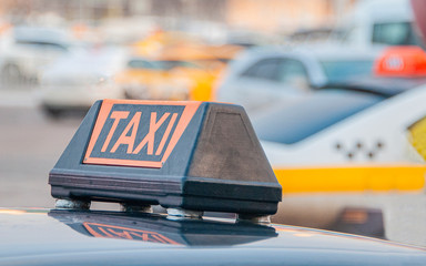 taxi cap on a car roof against the city
