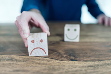 customer service rating and feedback concept with smiling and sad faces on wooden toy blocks