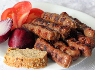 Kebabs, vegetables and bread served on the plate