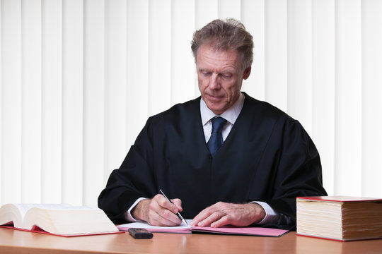 Judge or lawyer writing at his desk in a bright courtroom