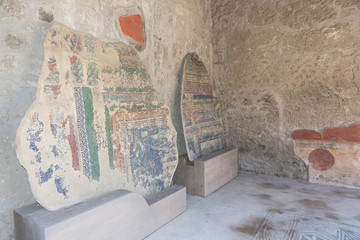 Fragments of walls with ancient paintings at a hall in a house in Roman city of Pompeii, Italy.