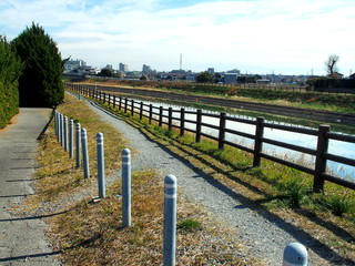Fototapeta premium 早春の土手の小道のある放水路風景