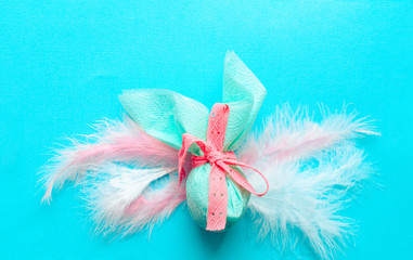 Egg gift in green paper packaging and with pink ribbon Easter Bunny wrap idea. Chocolate dragee...