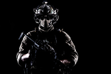 Army elite soldier with hidden behind mask and glasses face, in full tactical ammunition, equipped...
