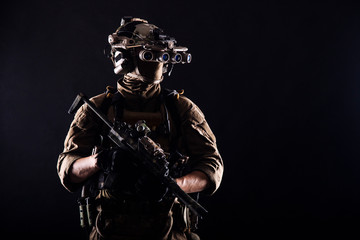 Army elite soldier with hidden behind mask and glasses face, in full tactical ammunition, equipped...