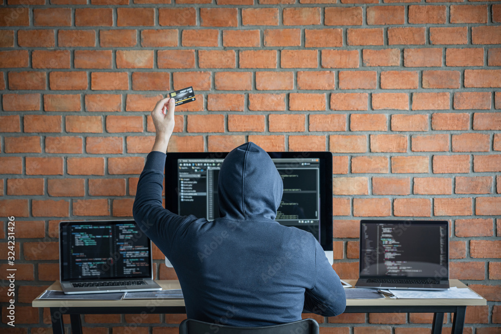 Poster Computer hacker or cyber attack concept, Dangerous hooded hacker using multiple computers typing bad data into online system the access with a virus to infect steal information
