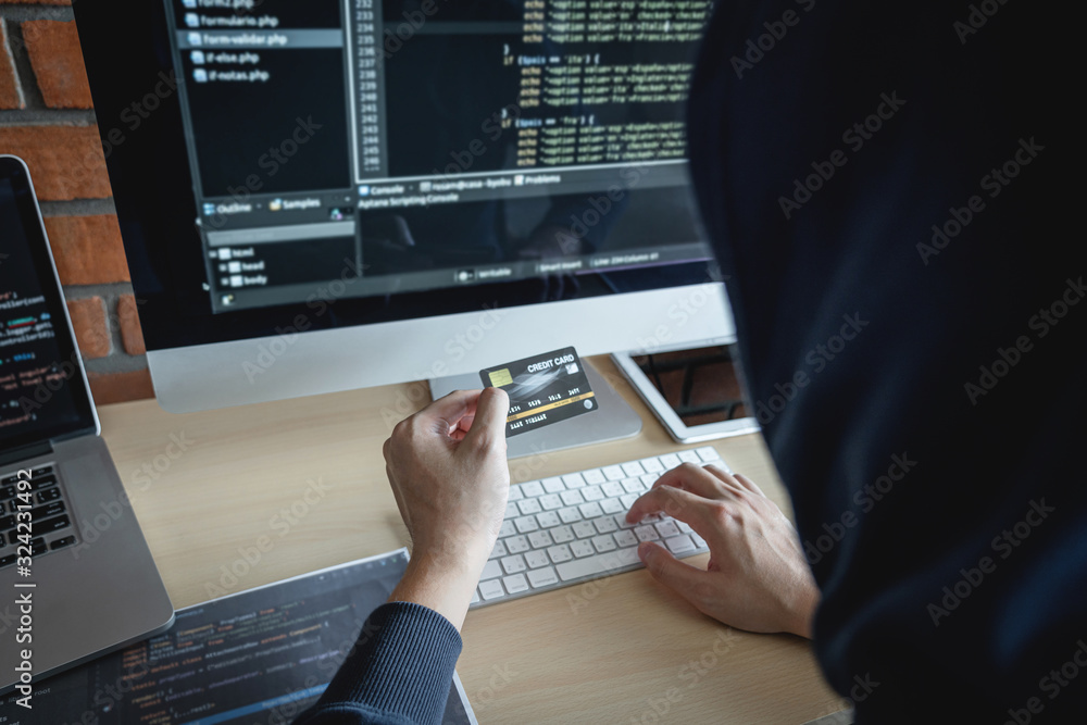 Poster Computer hacker or cyber attack concept, Dangerous hooded hacker using multiple computers typing bad data into online system the access with a virus to infect steal information