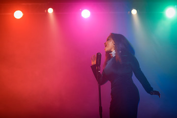 A jazz singer performs on stage. Afro.