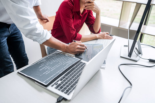 Two professional programmer cooperating and working on web site project in a software developing on desktop computer at company, codes and typing data code, Programming with HTML, PHP and javascript