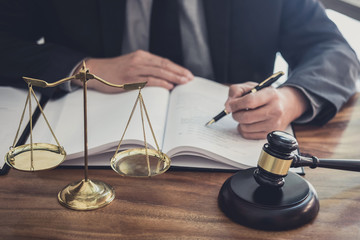 Male lawyer or judge working with contract papers, Law books and wooden gavel on table in courtroom, Justice lawyers at law firm, Law and Legal services concept