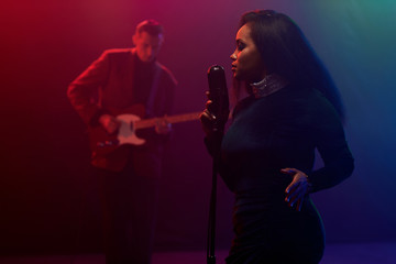 Obraz premium A jazz singer and guitarist perform on stage.