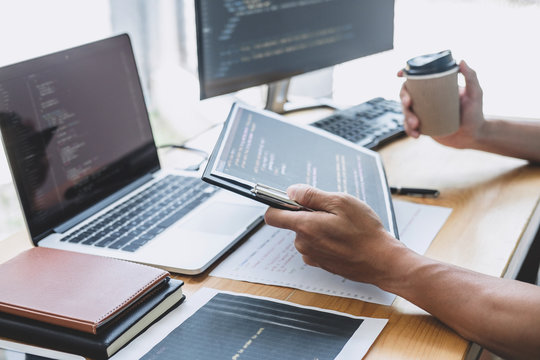 Young Professional programmer working at developing programming and website working in a software develop company office, writing codes and typing data code, Programming with HTML, PHP and javascript