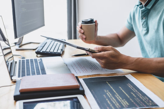 Young Professional programmer working at developing programming and website working in a software develop company office, writing codes and typing data code, Programming with HTML, PHP and javascript