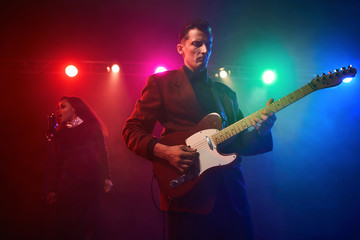 Obraz premium A jazz singer and guitarist perform on stage.