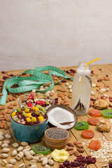 Fototapeta premium Muesli balanced breakfast. Fruits, berries seeds, nuts, coconut beverage, coconut protein vegetarian food