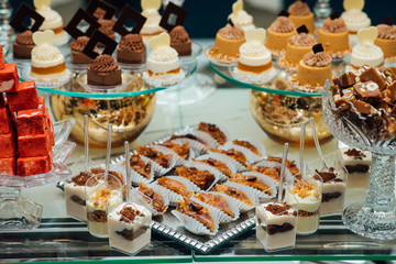 Candy bar, a table with sweets and desserts on the table. Buffet with delicious cupcakes, cake pops, biscuits