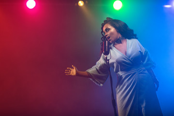 A jazz singer performs on stage. Afro.