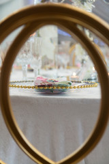 Obraz na płótnie Canvas Table setting with a glass plate through a golden chair back