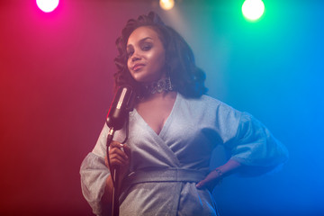 A jazz singer performs on stage. Afro.